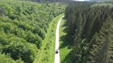 Drone-shot-following-a-forestry-worker-car-on-a-path-in-Verdun-forest.-France